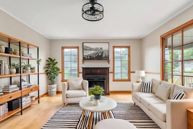 Living room in Ballston Spa home for sale with fireplace, sofa, and shelving.