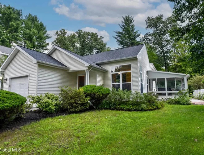 Suburban home with a well-manicured lawn, ideal for property buying.
