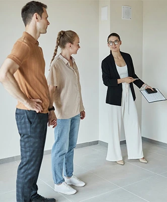 Realtor showing a property to a young couple; property selection.