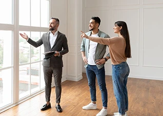 Couple on property tour with real estate agent, looking at a window.