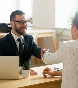 Man in suit shaking hands with client.