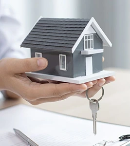 Hand holding a model house with keys, ideal for Effortless Tours property viewings.