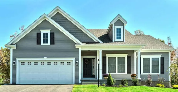 Modern gray house with white trim and a two-car garage, ideal for real estate.