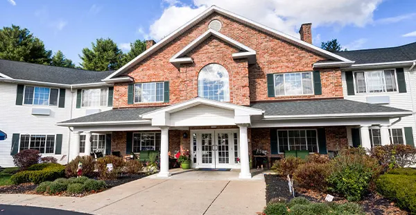 Front entrance of a brick real estate property with plants and shrubs