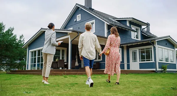 Real estate agent shows a couple a modern blue house.